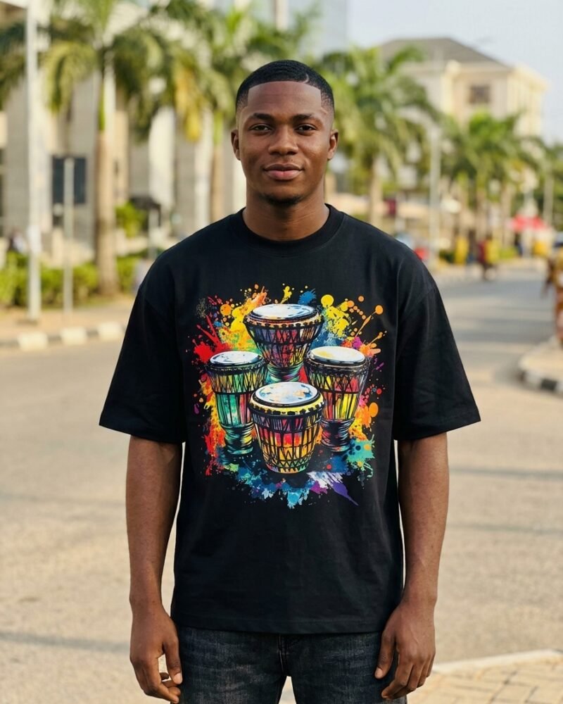 Young Nigerian man in Abuja wearing the Shakara Drip Four Drums One Beat oversized black graphic tee