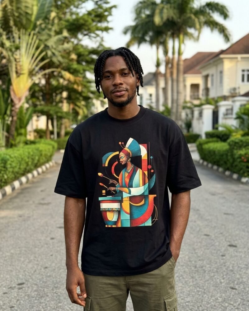 Young Nigerian man in Maitama Abuja wearing the Shakara Drip Green Robe Drummer oversized black graphic tee